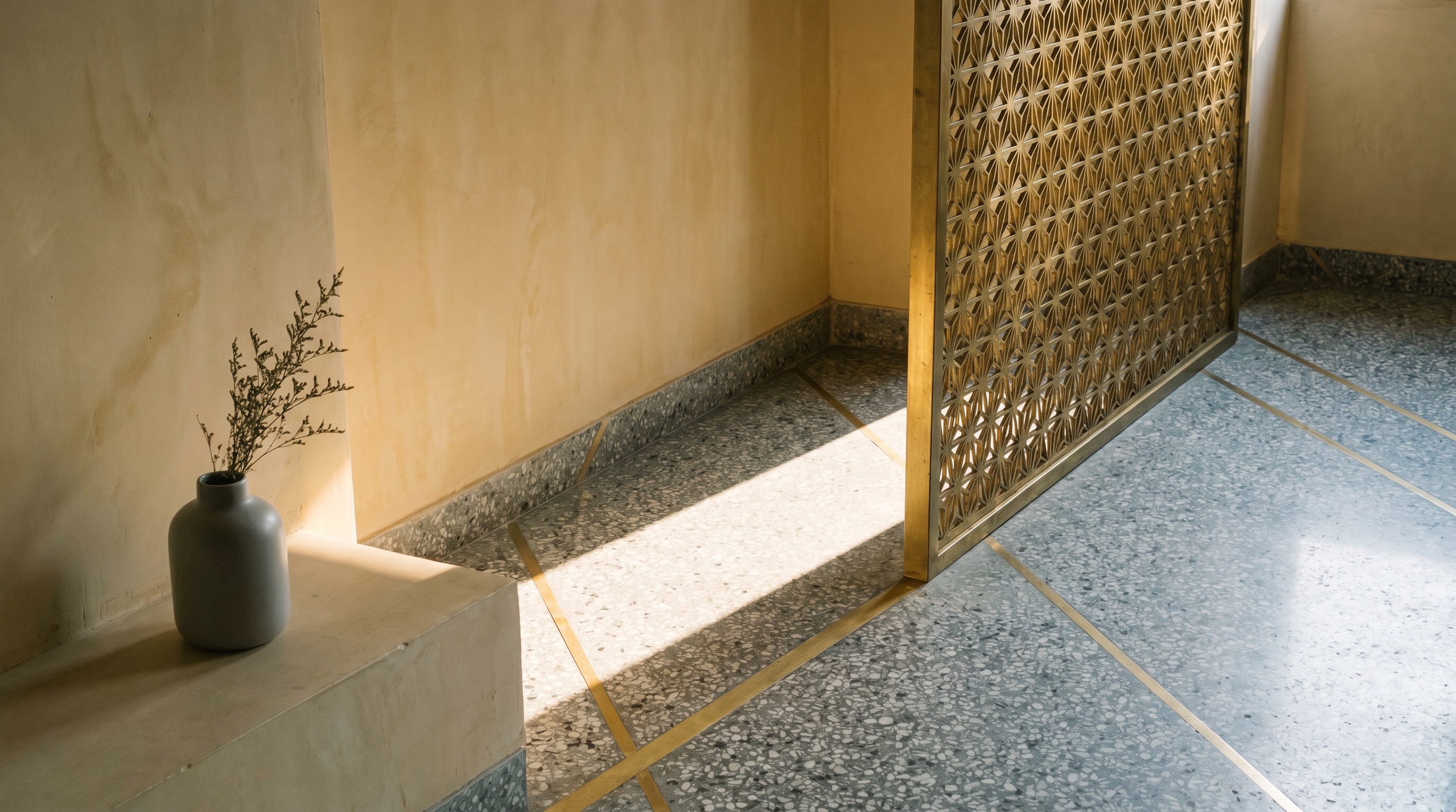 A modern Indian restaurant interior with raw lime plaster walls, brass jaali screen, terrazzo flooring and hand-thrown ceramic table tops